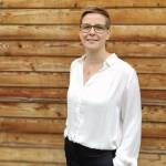 Manuela Meyer steht vor Holzwand