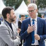 Von links Dezernent Benjamin Koppe im Gespräch mit Dr. Thomas Knoll (Referat für Digitales und Kreativwirtschaft - TMWWDG). Im Hintergrund ein unscharfer Blick über den Marktplatz.