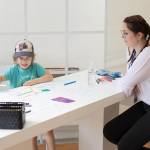Ein Kind und Projektassistentin Vanessa Huber am Maltisch des Smart City Standes