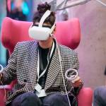 Eine Frau auf einem pinken Sessel mit einer VR-Brille auf