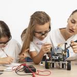 Mädchen und Lehrerin machen Wissenschaftsexperimente zusammen mit Roboterauto.