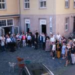 Viele Menschen stehen vor einem Gebäude und freuen sich.