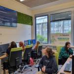 Schülerinnen sitzen in einem Raum von der Firma dotSource und schauen sich Monitore an.