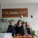 Das Team vom ProbierLaden steht am Empfangstresen und lächelt in die Kamera.