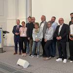 Gruppe von Menschen steht auf einer Bühne.