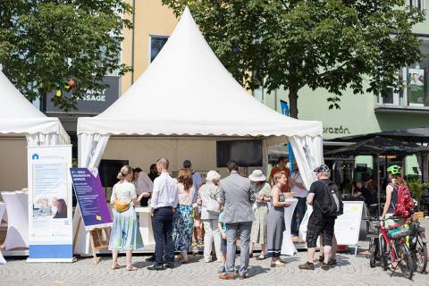 Blick von vorn auf das Smart City und 5G Infozelt. Zahlreiche Menschen sind im Gespräch miteinander.