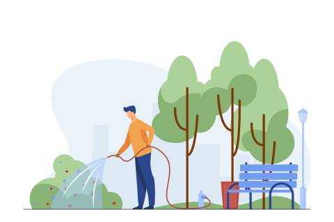 Mann bewässert einen Busch in einem Stadtpark
