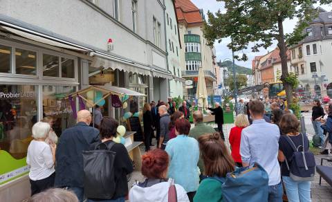 Viele Menschen stehen vor einem Laden.