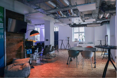 Innenansicht des JEDI - Jena Digital Innovation Hub mit Stuhlreihen und Stehtischen