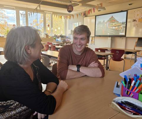 Mann und Frau sitzen an einem Tisch und unterhalten sich.