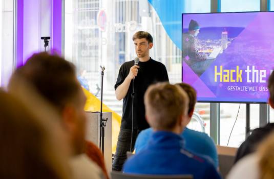 Domenique Dölz steht beim Smart City Forum und moderiert vor Publikum.