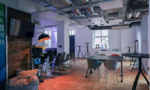 Innenansicht des JEDI - Jena Digital Innovation Hub mit Stuhlreihen und Stehtischen