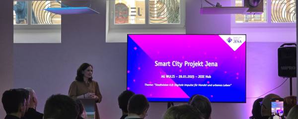 Smart-City-Gesamtprojektleiterin Dorothea Prell steht vor einem Publikum und hält einen Vortrag zum Thema Smart City Projekt Jena, digitale Impulse für Handel und urbanes Leben.