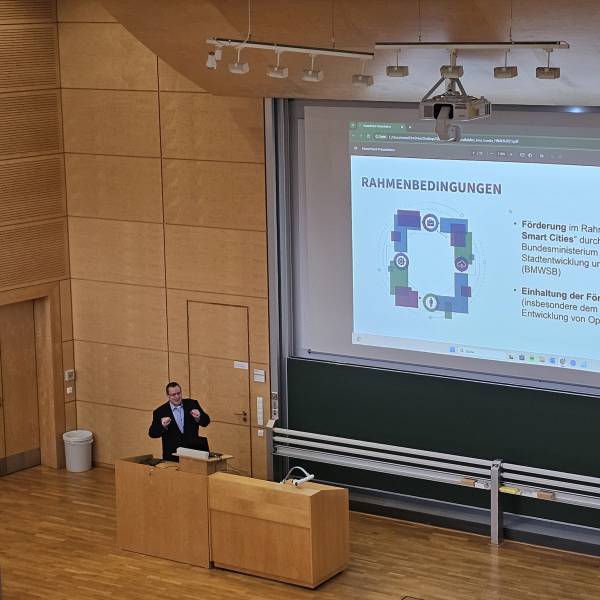 Mann steht am Podium und hält Vortrag in einem Uni-Hörsaal.