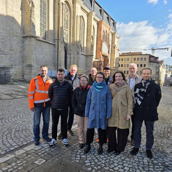 Viele Menschen schauen in eine Kamera.
