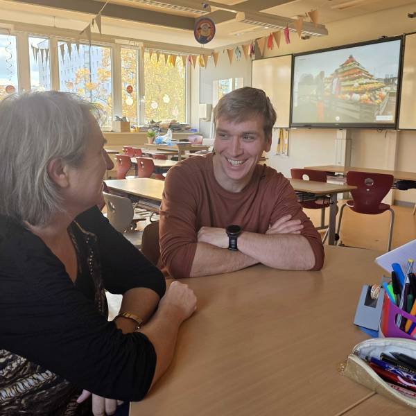 Mann und Frau sitzen an einem Tisch und unterhalten sich.