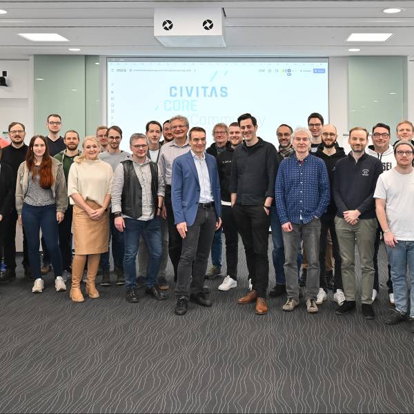 Menschengruppe schaut in die Kamera.