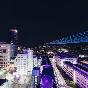 Jena bei Nacht mit vielen bunten leuchtenden Strahlen.