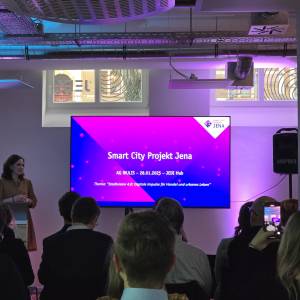 Smart-City-Gesamtprojektleiterin Dorothea Prell steht vor einem Publikum und hält einen Vortrag zum Thema Smart City Projekt Jena, digitale Impulse für Handel und urbanes Leben.