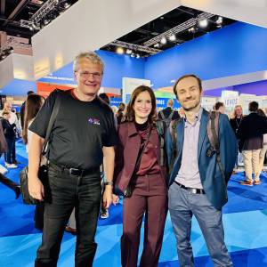 Drei Personen lachen in die Kamera.