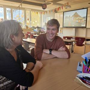 Mann und Frau sitzen an einem Tisch und unterhalten sich.